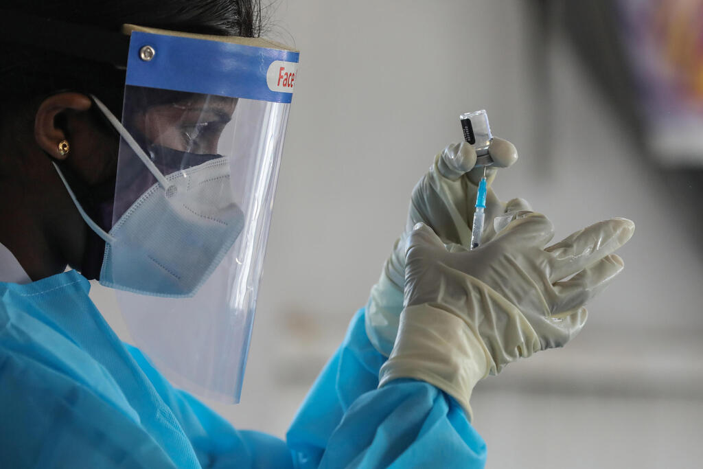 A medical worker in Sri Lanka prepares a dose of Pfizer's coronavirus vaccine (Photo: EPA) חיסון פייזר נגד קורונה ב סרי לנקה