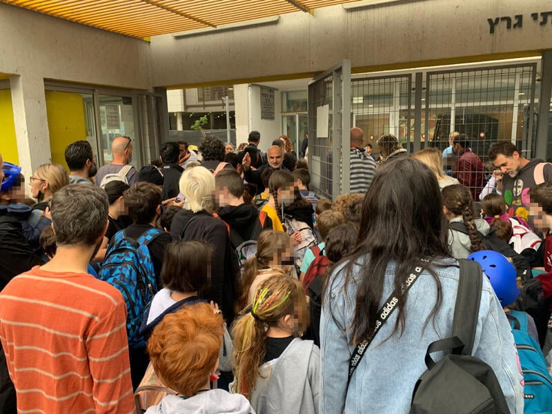Parents and kids gather around a school entrance, not wearing any masks or keeping distance (Photo: Adit Mizrahi) התקהלות באישור בדיקות האנטיגן בבית ספר גרץ בתל אביב