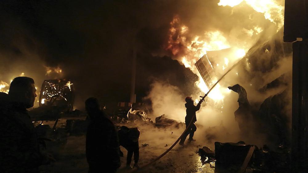 firefighters work at the scene of missiles attack, at the seaport of the coastal city of Latakia, Syria 