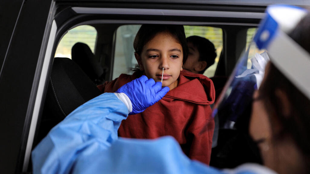 A girl undergoing COVID testing in Jerusalem (Photo: Reuters) תורים במתחם דרייב אין בדיקות PCR קורונה בירושלים
