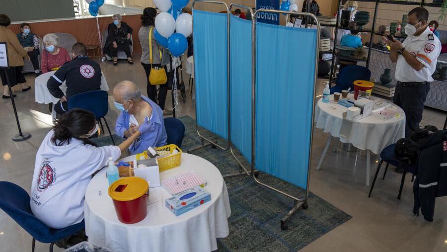 A man receives his fourth dose of the coronavirus vaccine in a private nursing home in Petah Tikva 