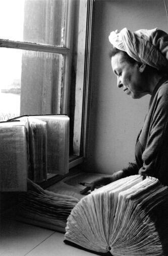 תצלום שחור-לבן של האמנית הלן אילון מסמנת חומשים בסטודיו שלה בניו-יורק, שנות ה-90 של המאה ה-20