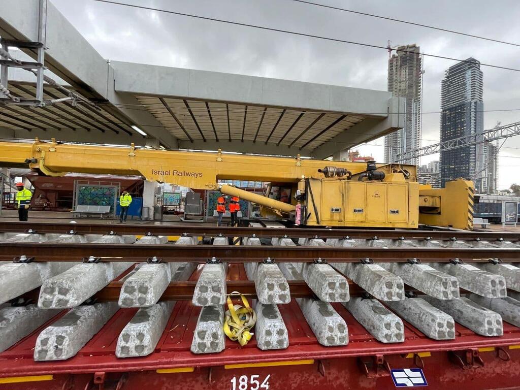 צילום: דוברות רכבת ישראל פסי רכבת חדשים שממתינים להתקנה ורכבת בודדת שמתמרנת ביניהם