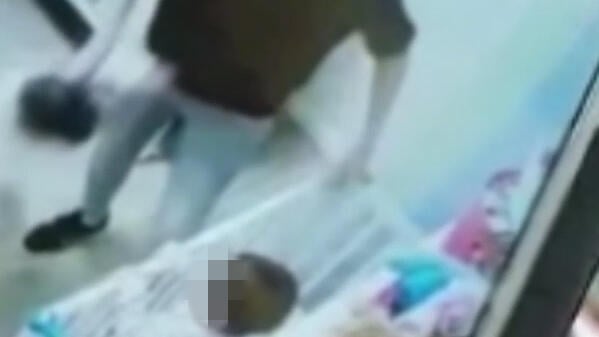 נושאת באמצעות החולצה, כאילו היה חפץ תיעוד מ"פעוטון הזוועות" בפתח תקווה