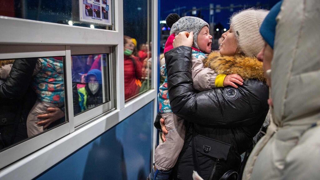 Ukrainian women and children wait to cross the Slovakian border fleeing the Russian invasion on Friday (Photo: AFP) תושבים שברחו מאוקראינה הגיעו לגבול סלובקיה