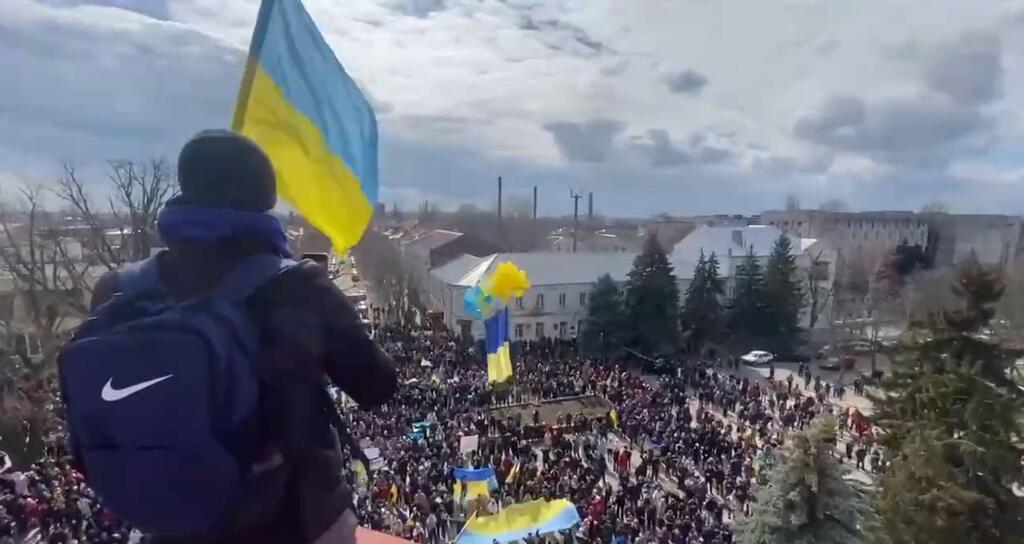 Ukrainian civilians in Nova Kakhovka, near Kherson, protesting Russian occupation (Photo: Twitter) מפגינים הפגנה ב עיר נובה קחובקה באזור חרסון עם דגלי אוקראינה אחרי שהעיר נכבשה בידי כוחות רוסיה מלחמה