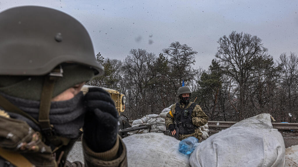 Ukrainian volunteers for service await invading Russian armor as it is heading towards Kyiv on Monday 