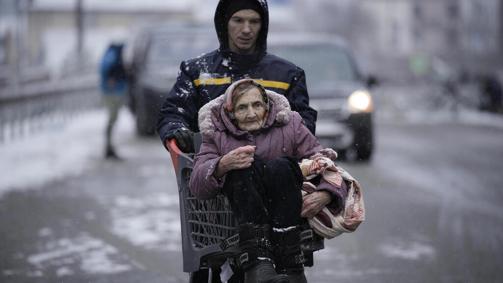 Fleeing Kyiv during ceasefire on Tuesday (Photo: AP) נושאים קשישה על אופניים פינוי מ אירפין שבפרברי קייב אוקראינה מלחמה 8.3