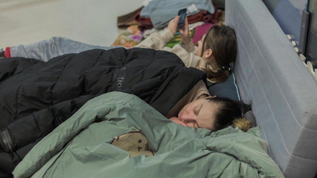 A Ukrainian woman and her children sleep on the floor of a train station in Poland (Photo: Reuters) פליטים מאוקראינה בתחנת הרכבת של ורשה