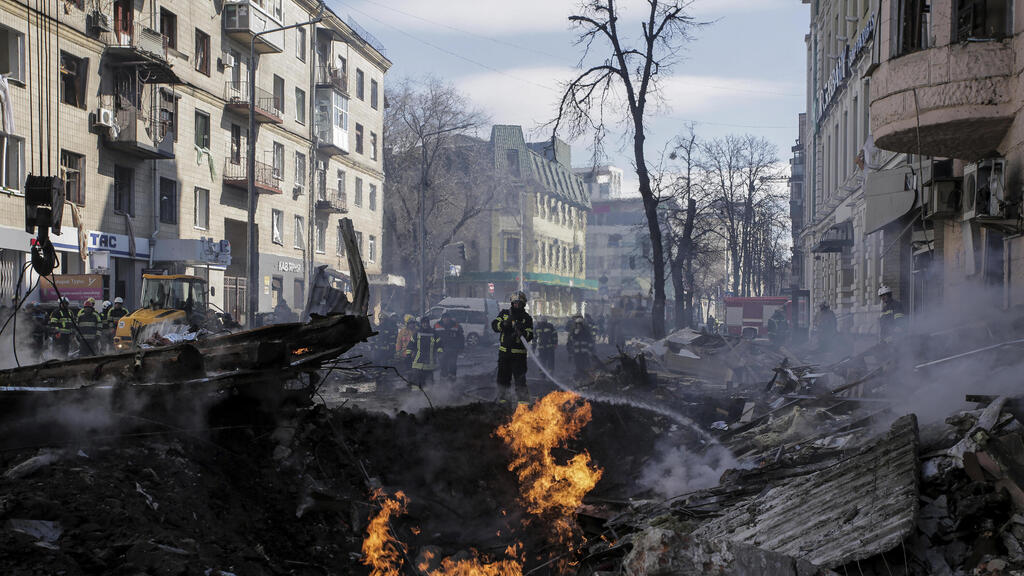 Fire in a crater caused by a Russian bomb aimed at a residential street in Kharkiv (Photo: AP) חרקוב כבאי מכבה שריפה בבניין מגורים