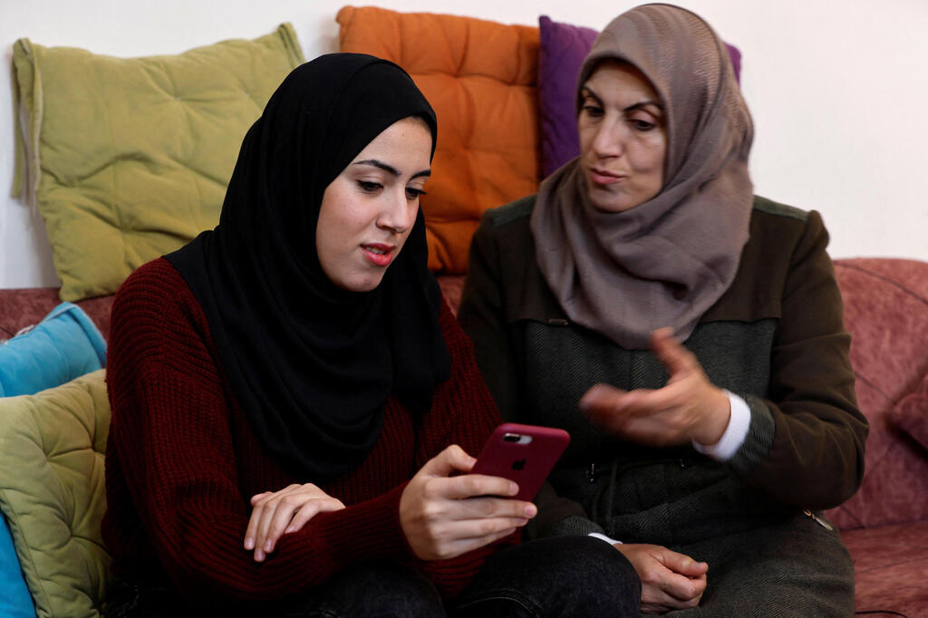 Samar Aita, who studied in Ukraine, chats with her mother at her house, in Rafah 