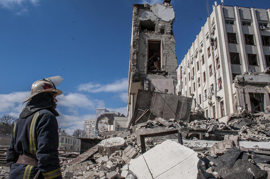 Rescuers try to find people underneath the rubble in the aftermath of a Russian bombardment, in Kharkiv, Ukraine (Photo: AP) כוחות הצלה בחרקוב, אוקראינה