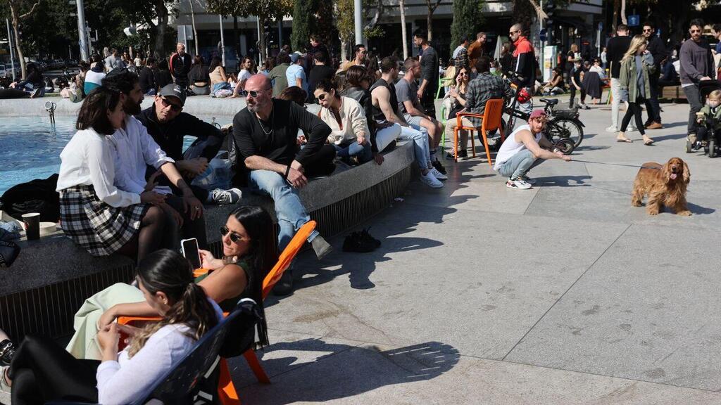 אנשים נחים בשמש בשבת בכיכר דיזינגוף