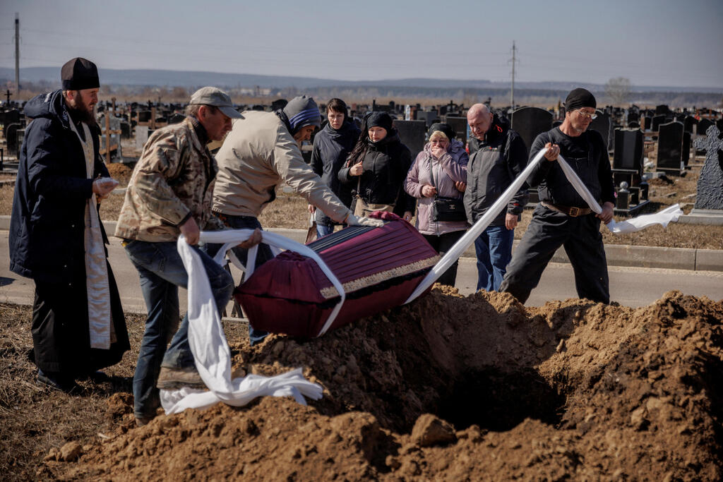 ארונו של ניצול השואה מורד אל הקבר, כמעט שבוע אחרי שנהרג (צילום: רויטרס) אוקראינה הלוויה ל בוריס רומנצ'נקו ניצול שואה בן 96 ש נהרג ב הפצצות ב חרקוב מלחמה עם רוסיה