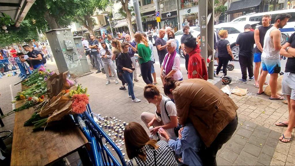 מדליקים נרות נשמה ומניחים פרחים בזירת הפיגוע בתל אביב (צילום: רועי עידן) אנשים הגיעו להדליק נרות ולהניח פרחים בזירת הפיגוע