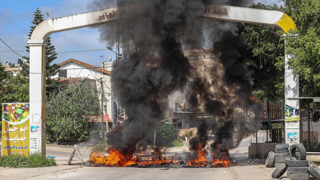 Burning tires at the entrance to the Jenin refugee camp during an Israeli raid to arrest terror suspects last week (Photo: AFP) פעילות כוחות הביטחון בג'נין