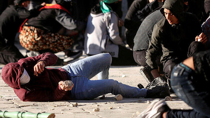 Palestinian holding a rock during clashes in Jerusalem (Photo: Reuters) התפרעויות בהר הבית