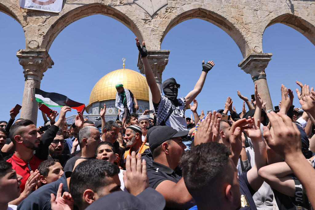 Palestinians riot at the Temple Mount (Photo: AFP) פלסטינים מסירים שלט של משטרה ישראל מהר הבית