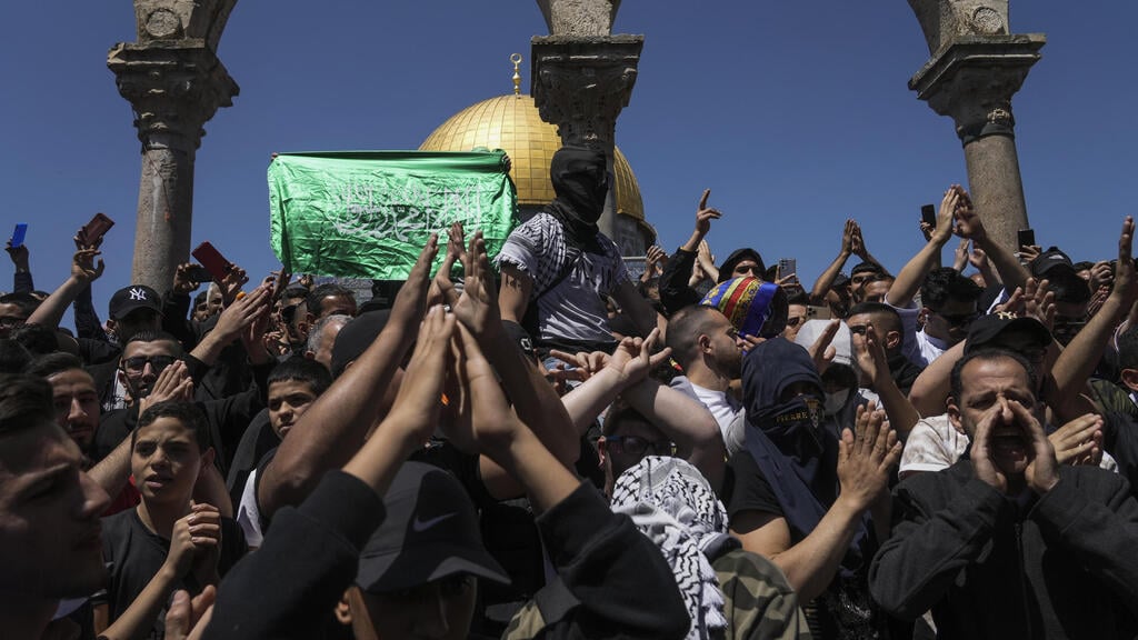 הפרה של הסטטוס קוו? "מלכודת של חמאס" (צילום: AP) לפסטינים מניפים דגלי חמאס בהר הבית