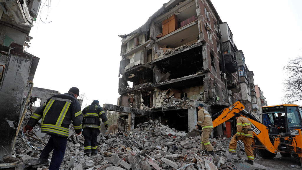 Rescue workers at a building destroyed by Russian shelling in Mariupol 
