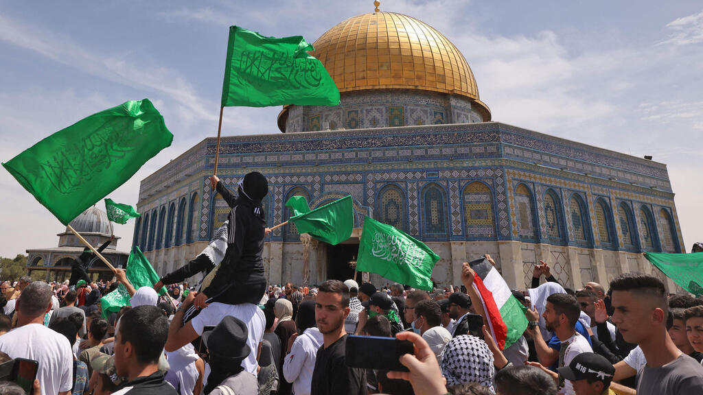 Palestinian rioters flying Hamas flags at the al-Aqsa Mosque compound (Photo: AFP) פלסטינים מנופפים בדגלי פלסטין וחמאס בהר הבית