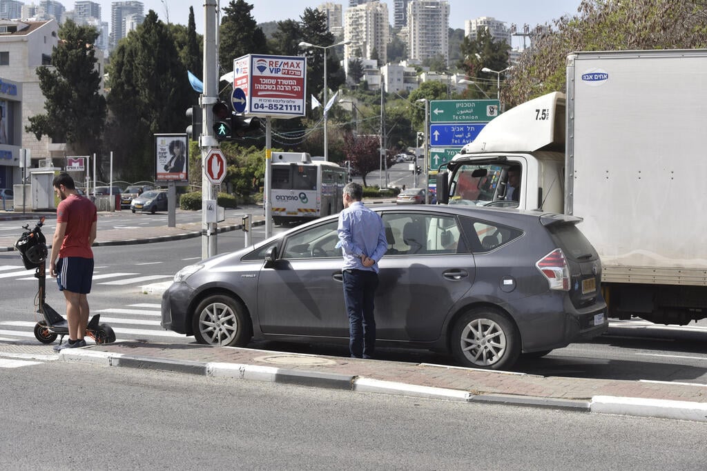  אנשים עומדים בצפירה בחיפה 