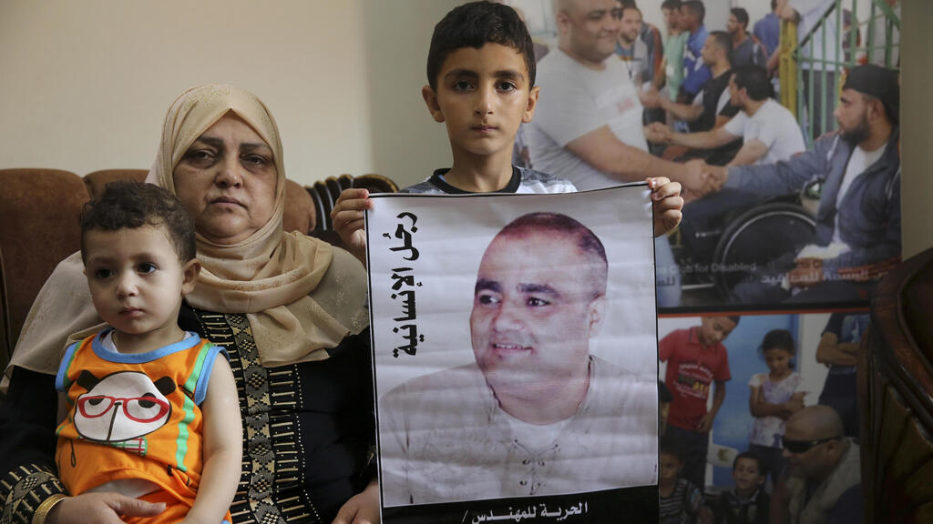  Amal el-Halabi holds her grandson Fares while her grandson Amro, 7, holds a picture of his father Mohammed el-Halabi 