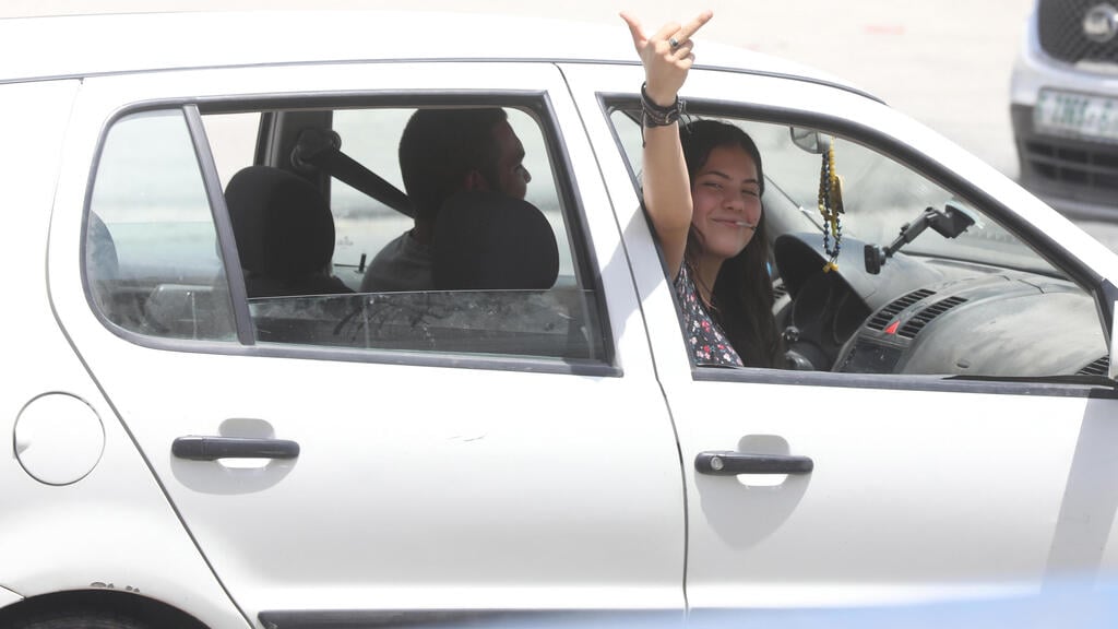Settlers make inappropriate gesture as the drive through the West Bank village of Huwara (Photo: EPA) עימותים בחווארה