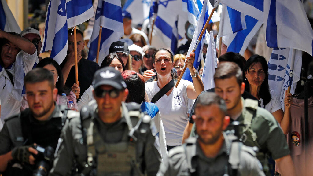 Israeli youth carrying flags march through the Old City of Jerusalem on Sunday (Photo: AFP) צועדים עם דגלי ישראל בעיר העתיקה