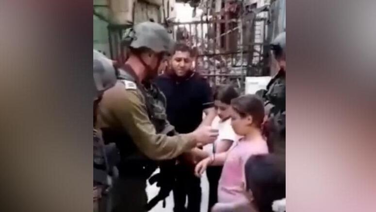 "תביא אזיקון". התקרית שתועדה ועלתה לרשתות החברתיות (צילום: מתוך טוויטר) תיעוד: קצין צה''ל עוצר ילדה בת 10 בחברון