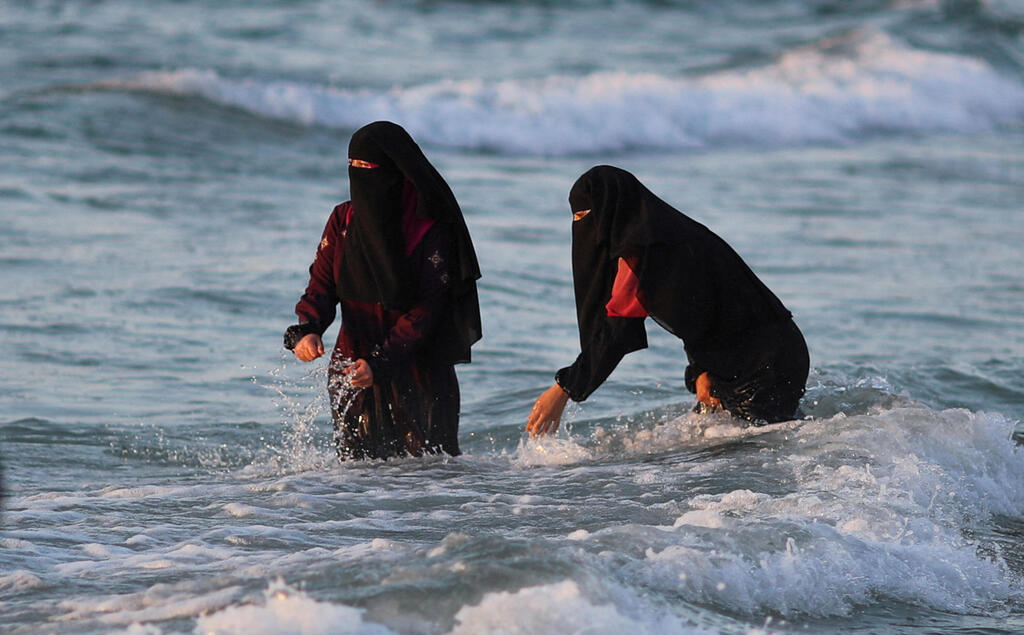 Gazan women enjoy the waves at the Gaza sea shore 