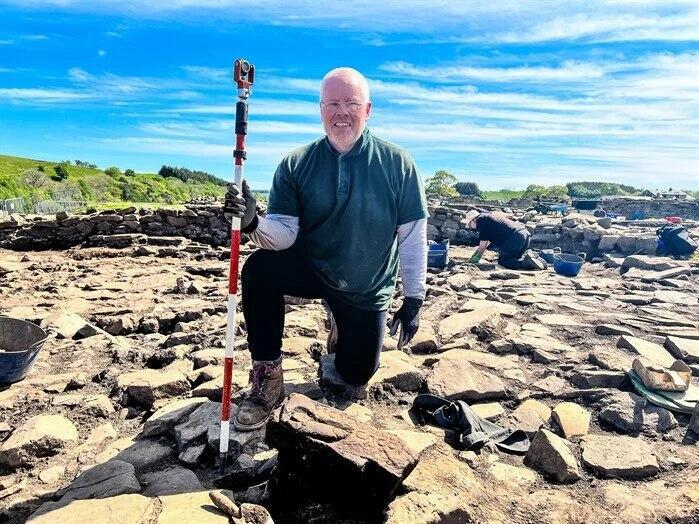 אחד החוקרים ליד סלע ועליו הציור (צילום: The Vindolanda Trust) אחד החוקרים ליד סלע ועליו הציור