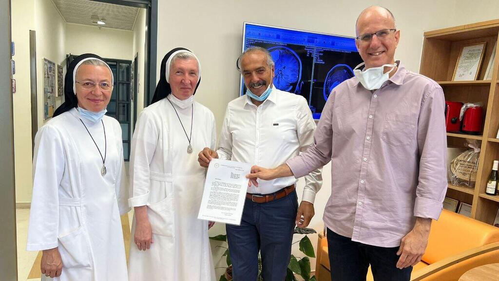 Sister Małgorzata Szałkowska (second from left) with her abbess and Drs. Adele Misk (center) and Nevo Margalit (Photo: Shaare Zedek Medical Center) הנזירה שלקובצקה מלגוז'אטה עם מכתב הוקרה מהוותיקן לאחר ניתוח להסרת גידול מוחי