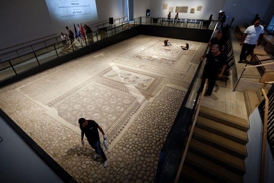 Workers clean a restored Roman-era mosaic 