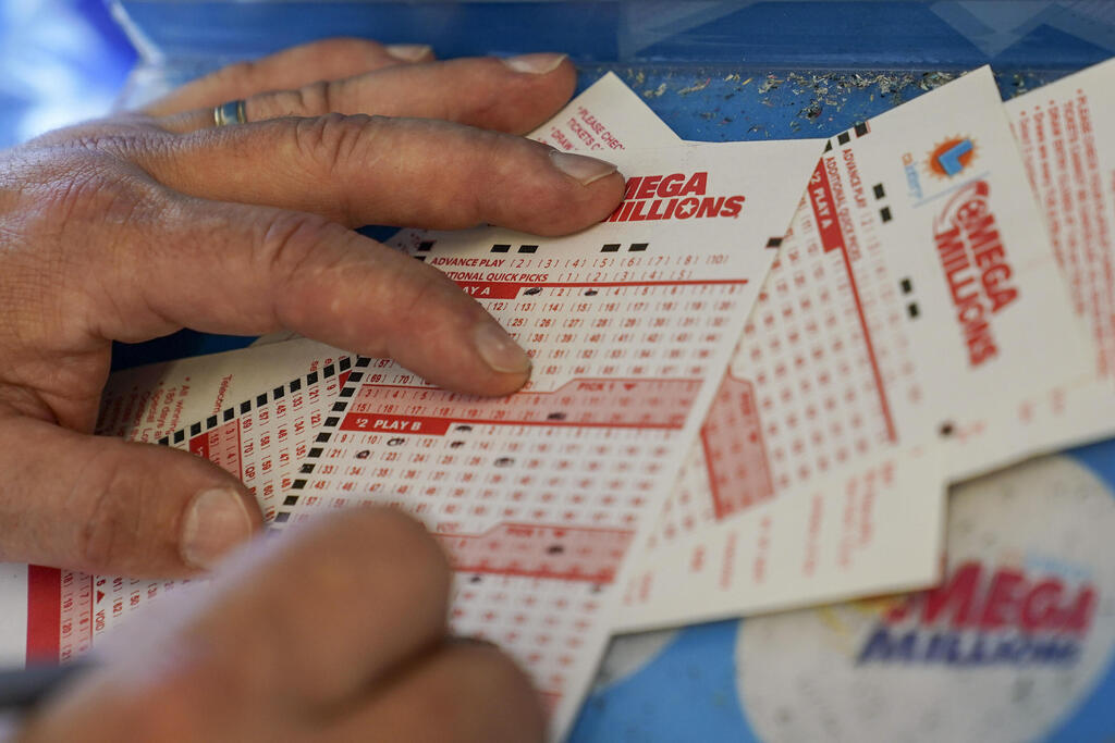 המנחש גורדון מידווייל ממלא טופס בקליפורניה. מי שיזכה בשבת וירצה את הכסף מיד - "יסתפק" ב-602.5 מיליון דולר (צילום: AP) ארה"ב פרס ראשון בלוטו Mega Millions יותר ממיליארד דולר המנחש גורדון מידווייל ממלא טופס ב קליפורניה