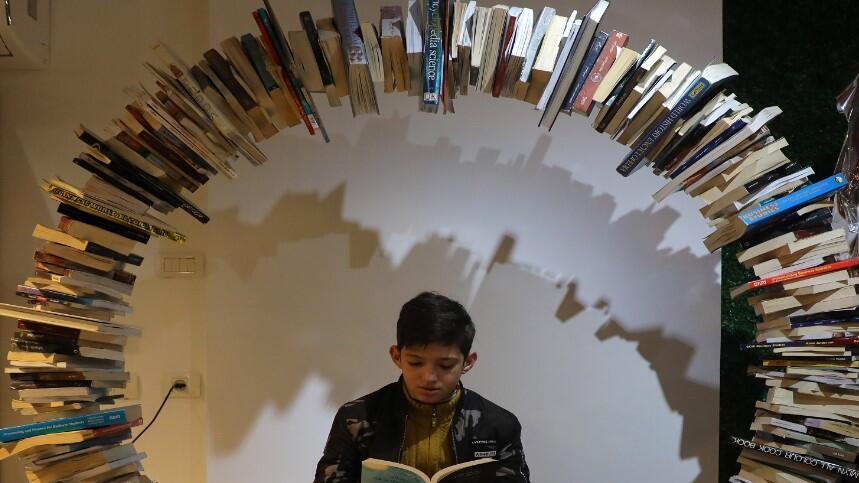 A Palestinian boy attends the reopening of the Samir Mansour bookshop 