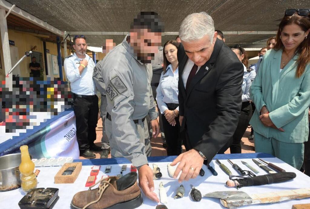 ביקור ראשון אחרי 37 שנים. לפיד סוקר טלפונים וכלי נשק מאולתרים שנתפסו בכלא הביטחוני "עופר", אתמול (צילום: עמוס בן גרשום, לע"מ) יאיר לפיד, עמר בר לב, קטי פרי ומירב בן ארי