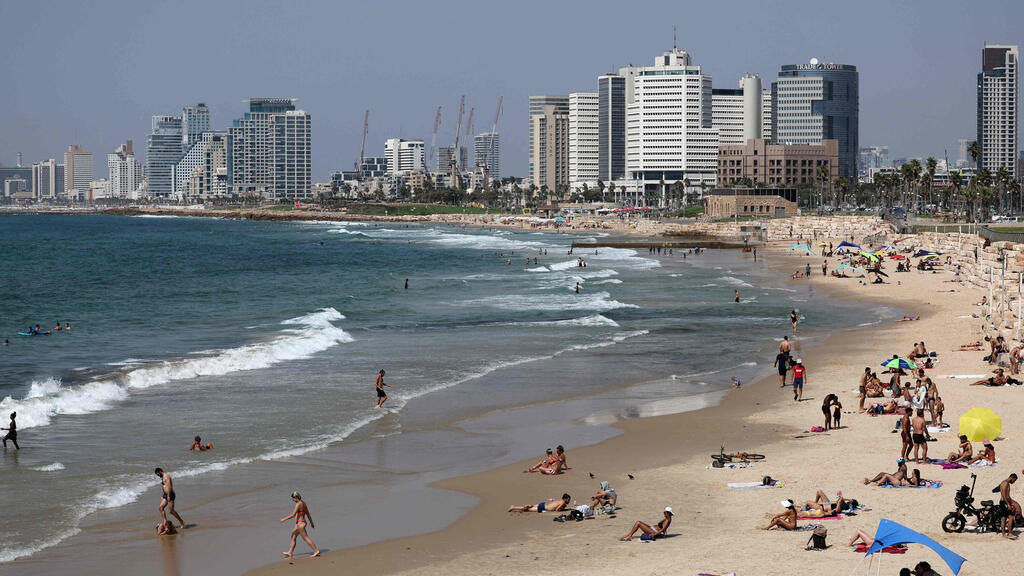 מתרחצים בתל אביב (צילום: AFP) חוף ים תל אביב מתרחצים בזמן מבצע עלות השחר