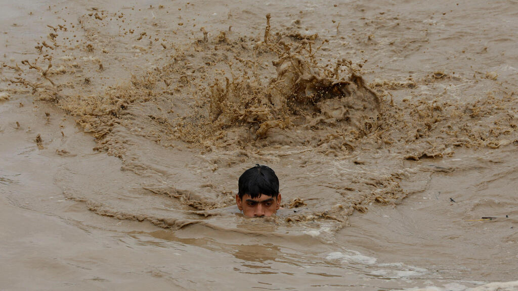 פקיסטן צעיר שוחה ב מי ה שיטפונות