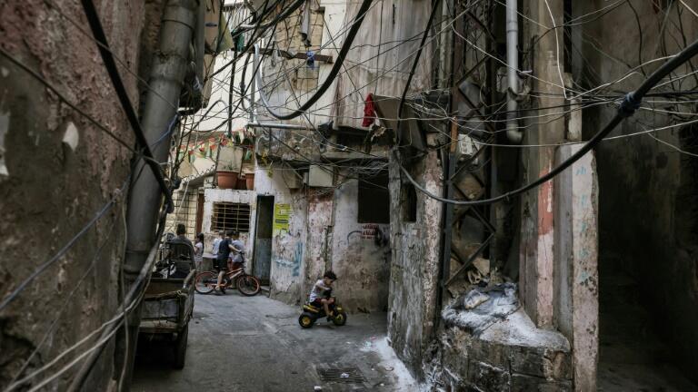 A Palestinian refugee child rides his tricycle along an alley in the Shatila camp for Palestinian refugees in the southern suburbs of Lebanon's capital Beirut 