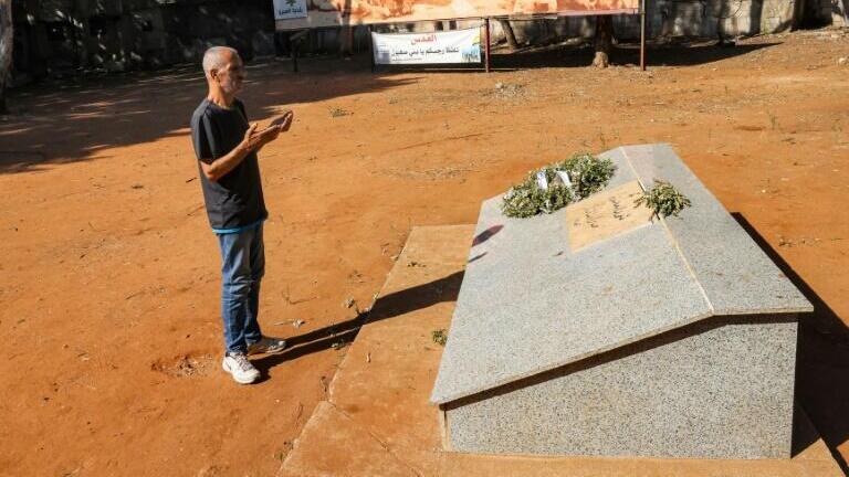 Amer Okkar, a former Palestinian militant, recites a prayer at the mass grave in Sabra 