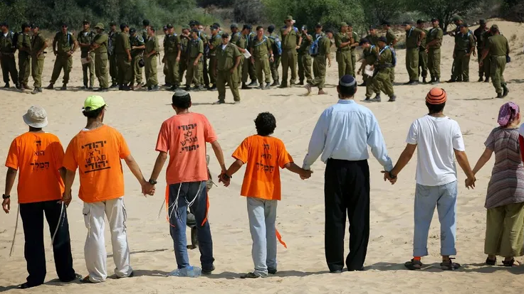 Israeli settlers link arms to prevent Israeli soldiers from entering the rear entrance to the southern Gaza Strip Gush Katif settlement of Neve Dekalim, 15 August, 2005 