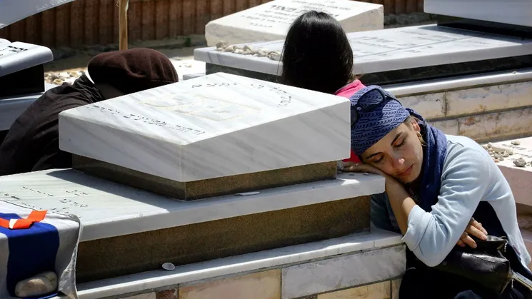 An Israeli mourns over the grave of a relative for last time prior to the uprooting of graves as part of Israel's ongoing disengagement plan, at the Gush Katif cemetery near the southern Gaza Strip settlement of Newe Dekalim August 23, 2005 