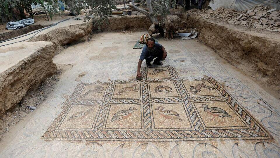 Palestinian farmer Salman al-Nabahin cleans a mosaic floor he discovered at his farm and which dates back to the Byzantine era 