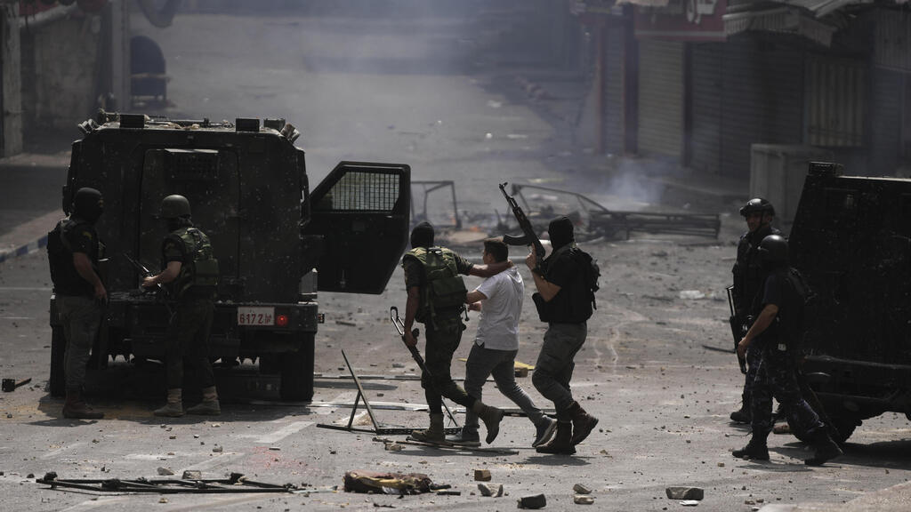 Palestinian security forces arrest a man during riots in Nablus on Tuesday
(Photo: AP) עימותים בין פלסטינים בשכם