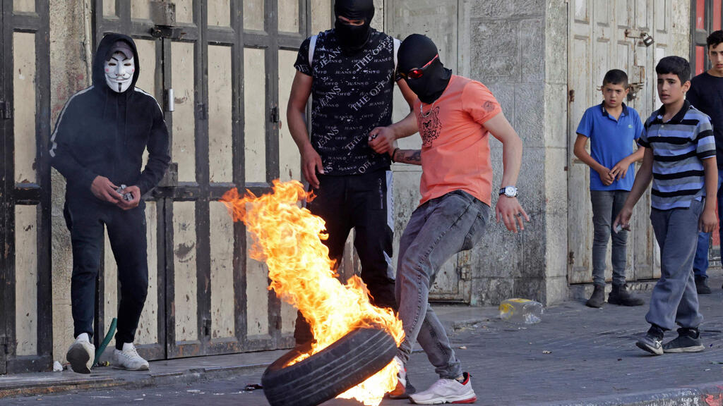 הפרות סדר בחברון. גורמי ביטחון חוששים: "הרמדאן יכול להיות הזדמנות לחמאס לגרור את יו"ש לטרור" (צילום: AFP ) הבערת צמיגים בחברון