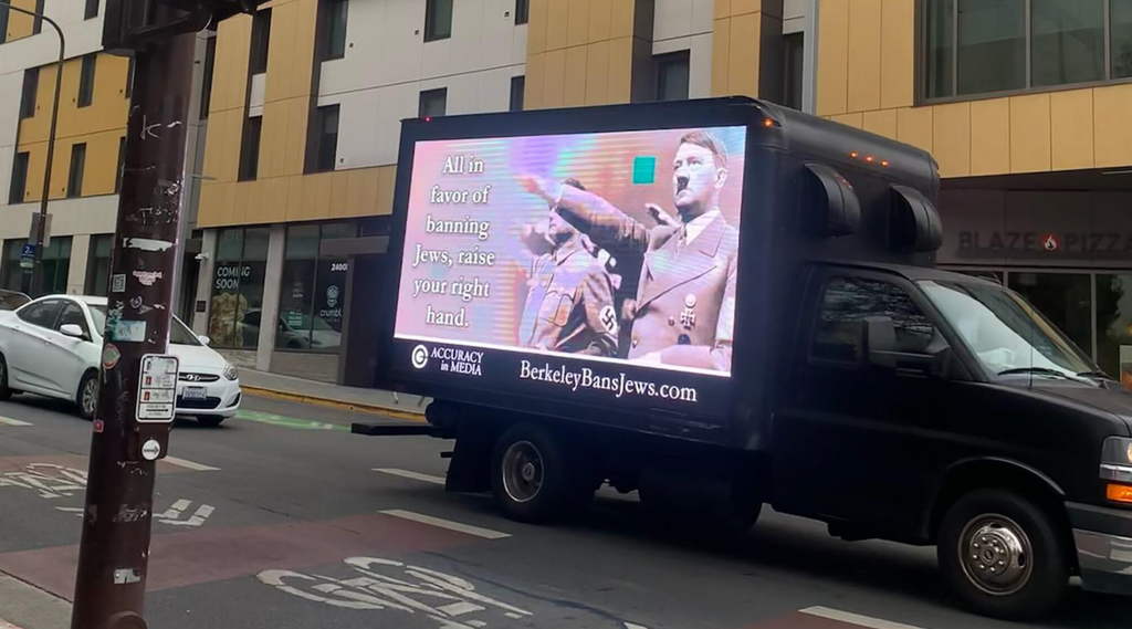 A truck emblazoned with an image of Adolf Hitler and the phrase ‘All in favor of banning Jews, raise your right hand,’ drove through Berkeley, Calif., October 2022, in response to a controversy involving several UC Berkeley Law student groups resolving to bar ‘Zionist’ speakers (Photo: Courtesy of Accuracy in Media via JTA) A truck emblazoned with an image of Adolf Hitler and the phrase ‘All in favor of banning Jews, raise your right hand,’ drove through Berkeley, Calif., October 2022, in response to a controversy involving several UC Berkeley Law student groups resolving to bar ‘Zionist’ speakers