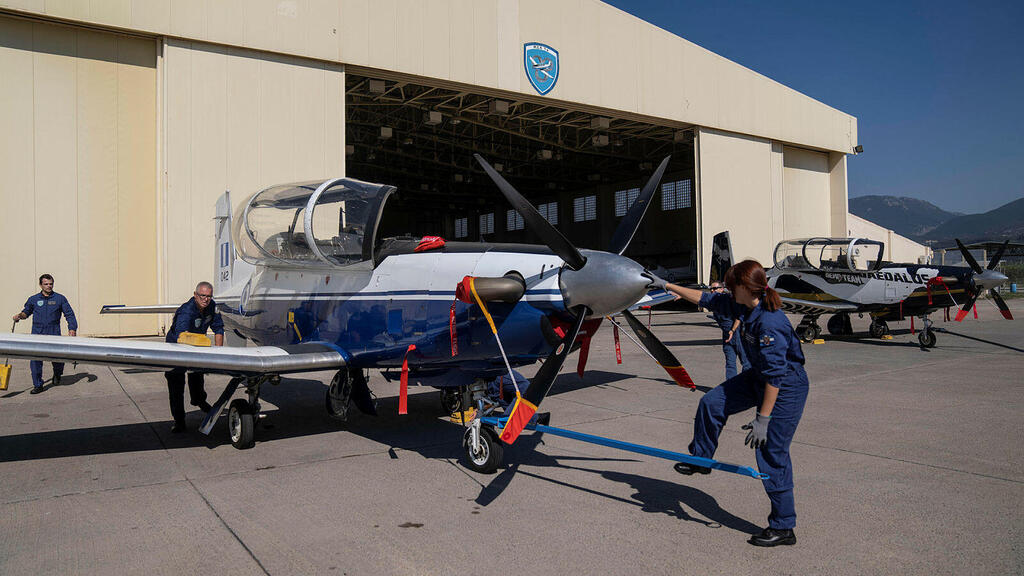 Greek airforce maintenance stuff park a T-6 single-engine turboprop training aircraft at an airbase 
