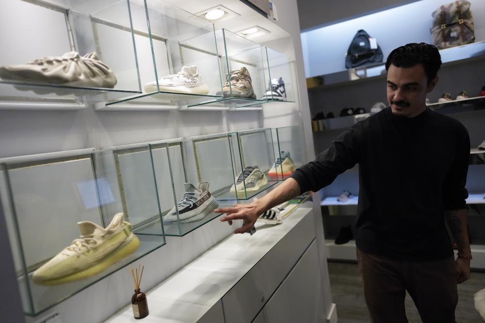 A store manager points out Yeezy shoes made by Adidas that are displayed inside cases at Addict shoe store in Brickell City Center in Miami, Tuesday, Oct. 25, 2022 