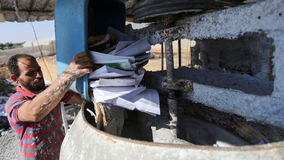 A Palestinian worker prepares paper waste during a process to recycle it into egg trays in Khan Younis, in the southern Gaza Strip, November 10, 2022 